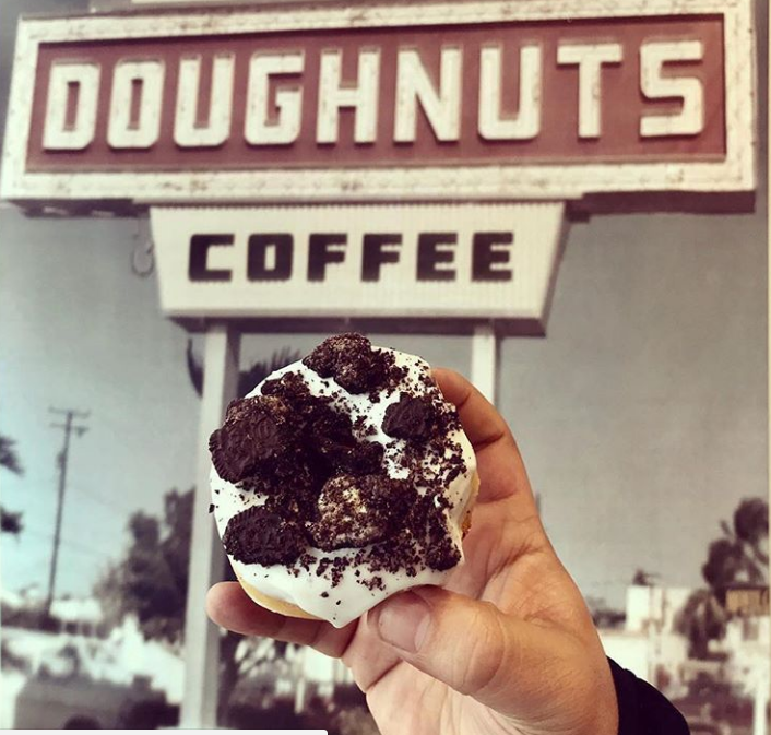image of foodie holding best doughnut in Miami.