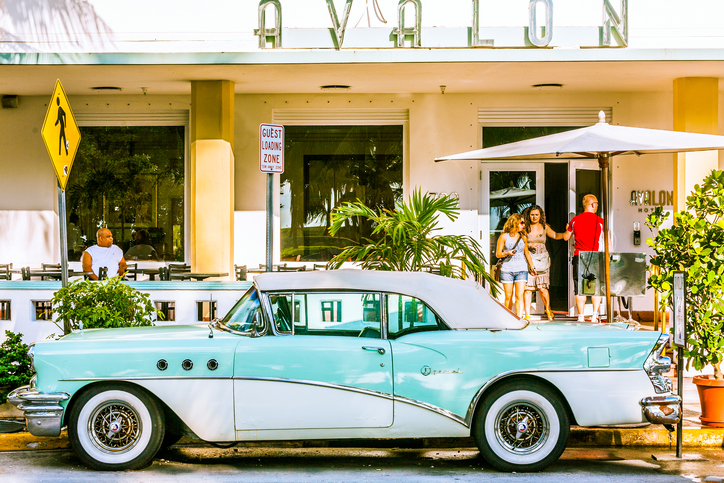 Classic car with chrome radiator grill parked in front of the restaurant in Hotel Avalon in Miami, USA.